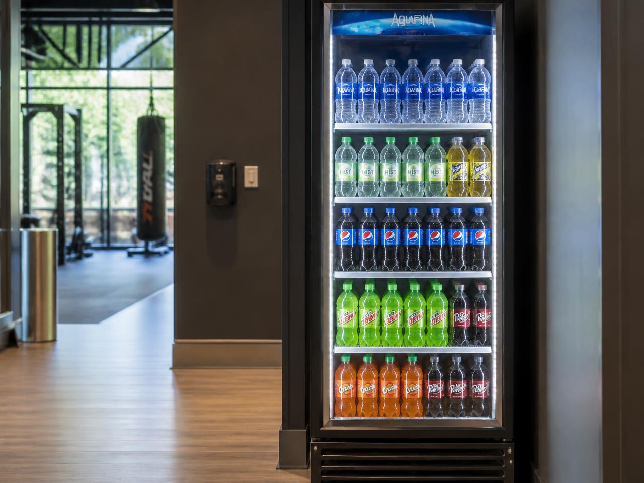 Refrigerated cold drink vending machine filled with bottled water and soft drinks